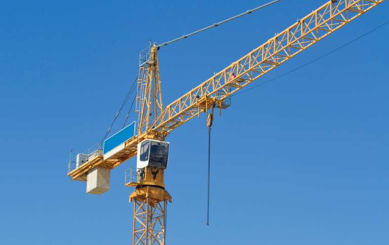 Baukran unter blauem Himmel – Symbol für Zuverlässigkeit, Präzision und Sicherheit im Kranservice von Elox Technik.